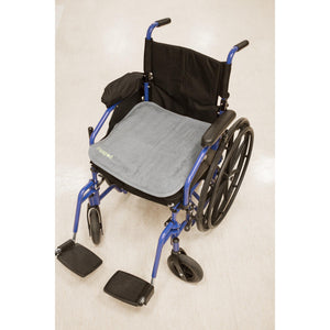 PeapodMats washable, reusable waterproof 1.5'x1.5' chair pad for bed wetting and incontinence, product illustration showing dark grey mat in wheelchair